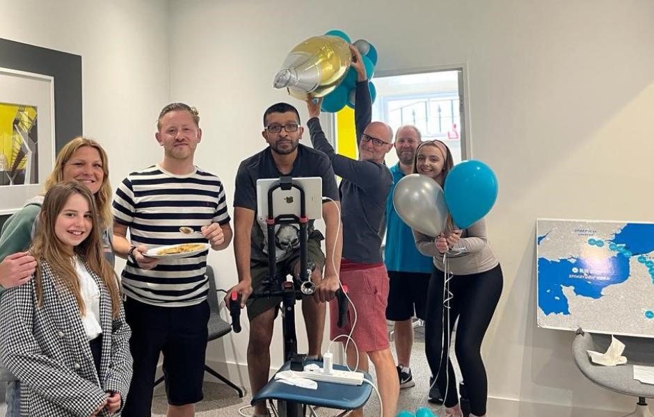 A group shot showing the charity spinathon team around the bike